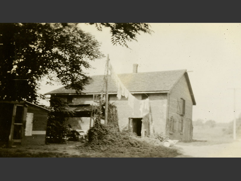 Two-story structure in a rural setting, wash drying on a line.